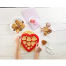 A piros színű, műanyagból készült puzzle kiszúró forma rácsos kialakítása egyszerre 12 darab, különböző méretű szív alakú sütemény precíz és hulladékmentes megformázását ...